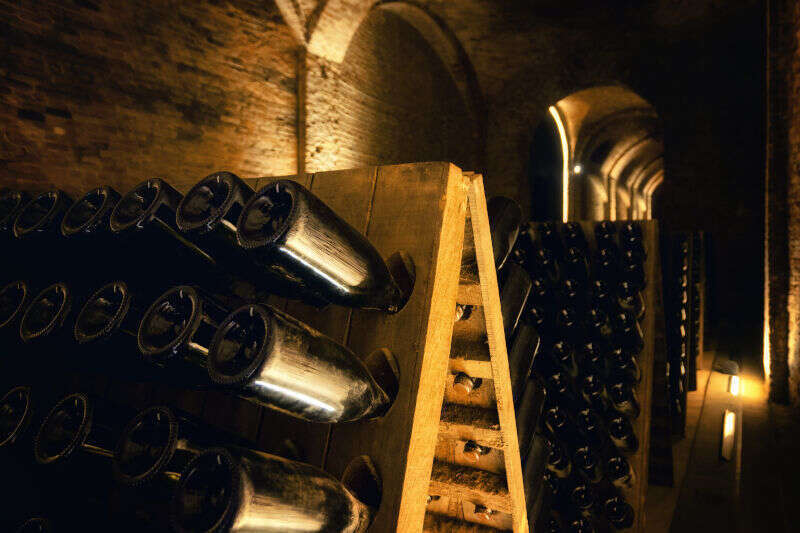Pupitre e bottiglie di champagne in cantina Pupitre e bottiglie di champagne in cantina